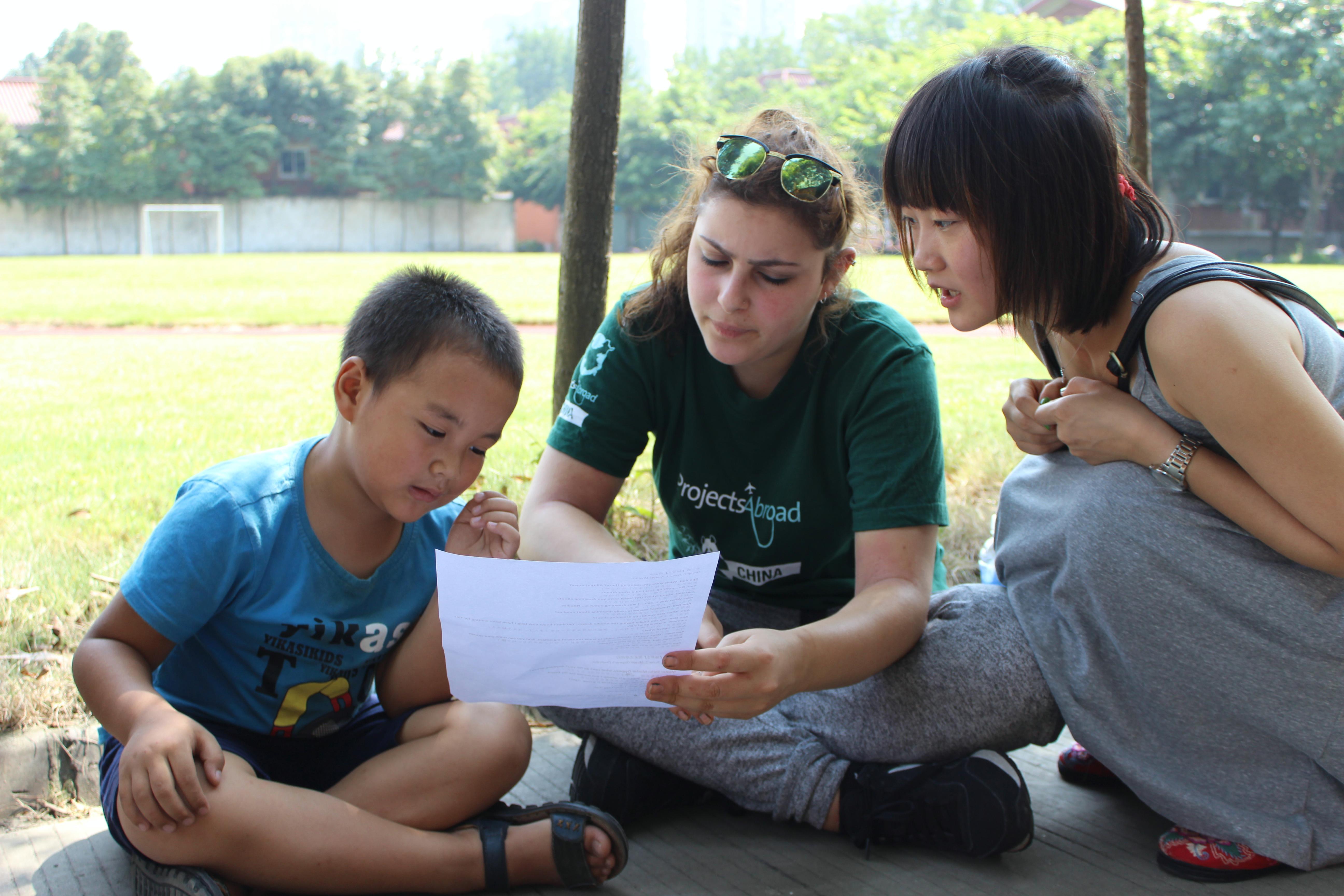 A young boy learns how to correctly pronounce English words while working with a Project Abroad volunteer teaching English in China A Teaching volunteer in China helps her student learn the lines of an English play